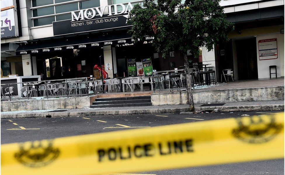 The exterior of the restaurant in Puchong district, outside Kuala Lumpur, on 28 June 2016, showing shattered glass on the floor and a line of police tape in the foreground.