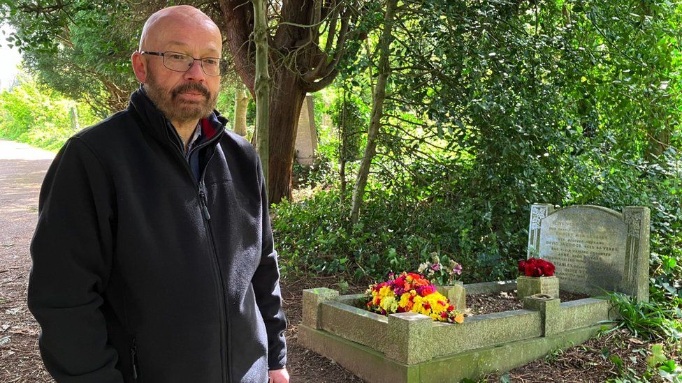 Image of Geoff Wilmott standing by a grave in Arnos Vale