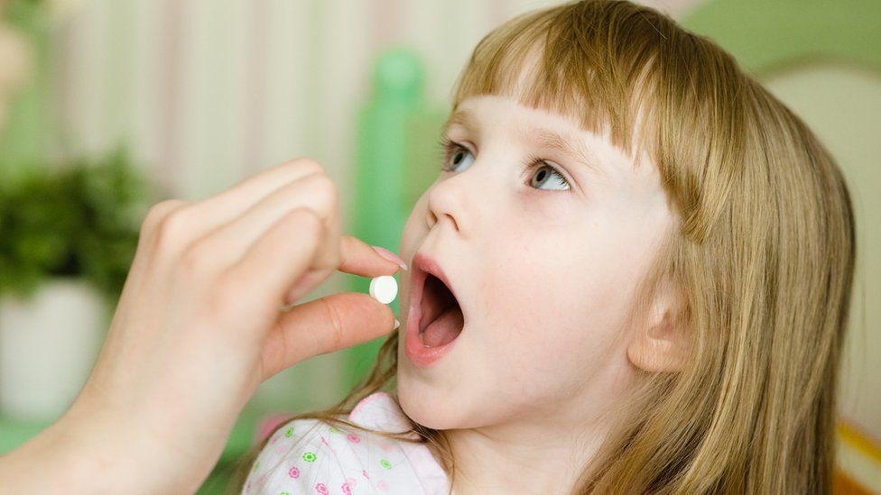 Girl taking a vitamin D pill