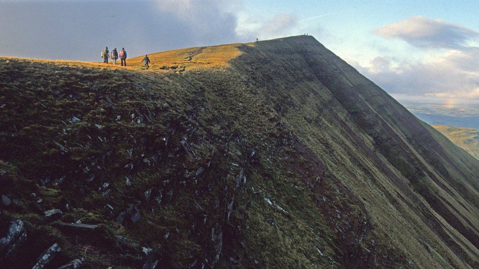 Walkers climbing up to the summit of Fan y Big
