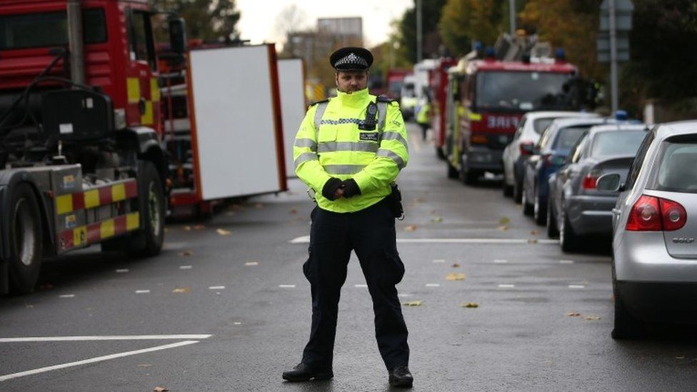 A police officer stands on duty near to the scene of a derailed tram, in Croydon,
