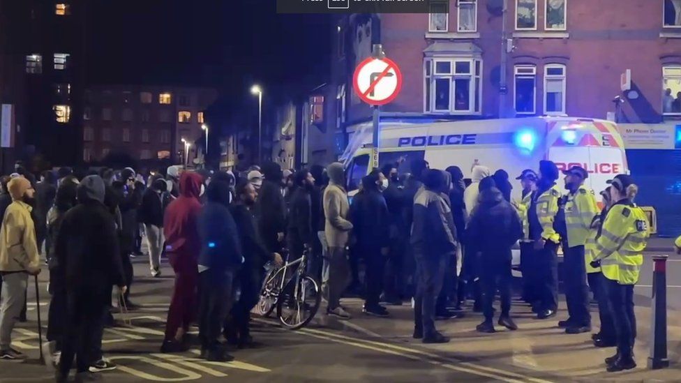 Crowd of people and police officers in Leicester