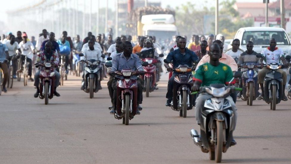 People ride their mopeds out on the streets the morning after the military barracks of the elite presidential guard (RSP) was taken over in Ouagadougou, 30 September 2015