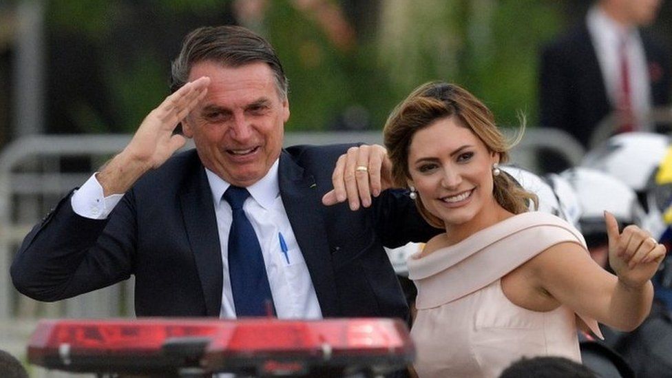 Brazil's President-elect Jair Bolsonaro (L) gestures next to his wife Michelle Bolsonaro as the presidential convoy heads to the National Congress for his swearing-in ceremony, in Brasilia on January 1, 2019