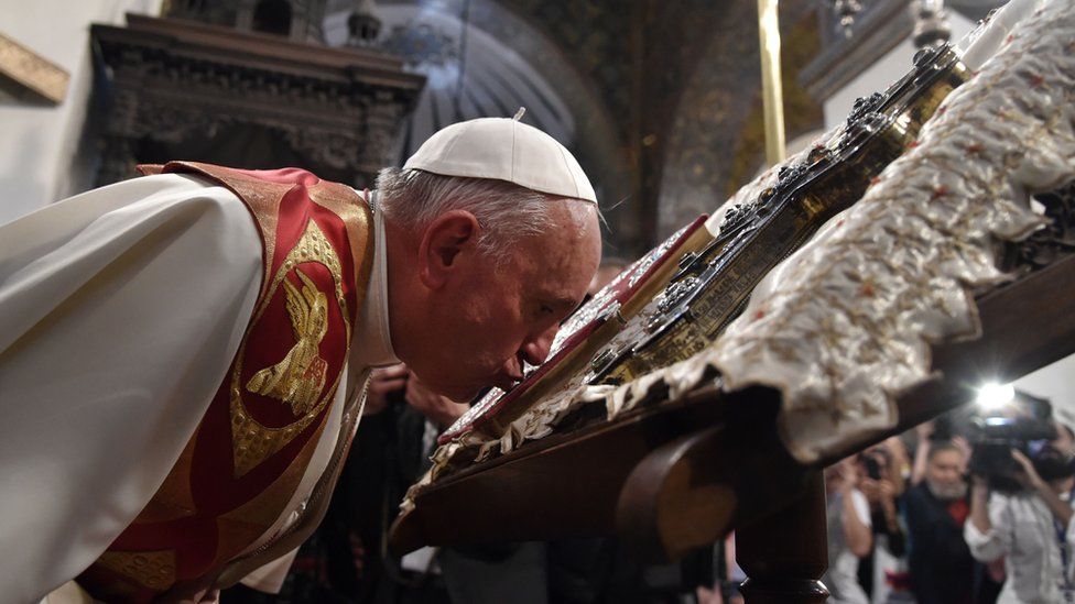 Pope Francis kisses the Holy Book as he visits the Apostolic Cathedral in Etchmiadzin, outside Yerevan, on 24 June