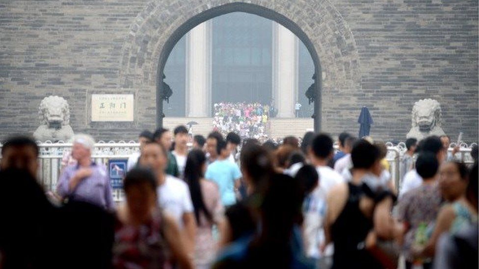 People walk through an arch in Beijing on July 16, 2014.