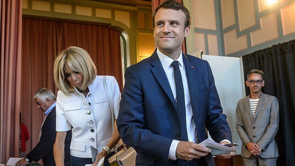 French President Emmanuel Macron (R) votes with his wife Brigitte Trogneux in Le Touquet, northern France, 11 June 2017