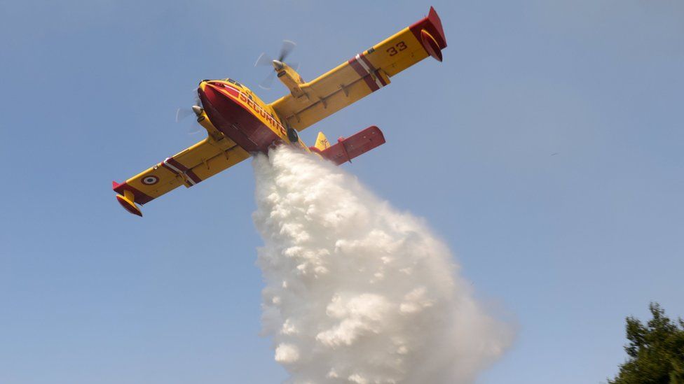 A French Civil Security "Canadair CL-415" firefighting plane drops water over a blaze in Cadafaz, Gois region, central Portugal, 21 June 2017