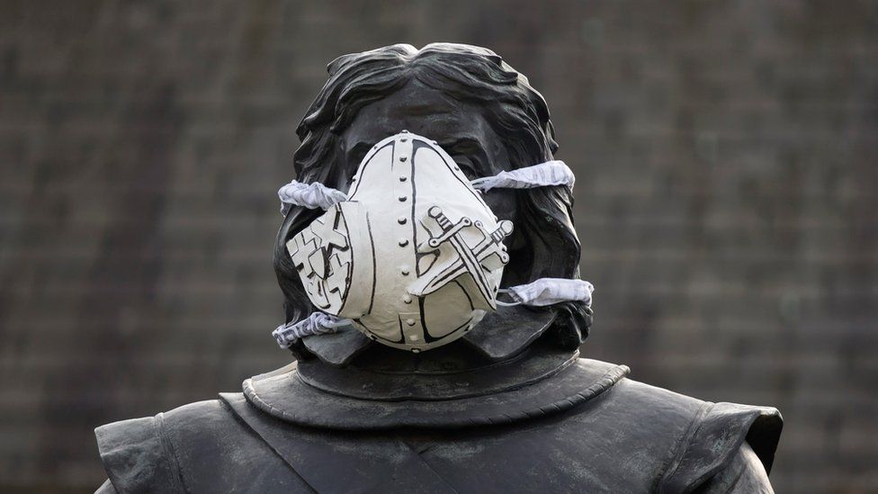A custom-made clean air mask is seen placed on the face of the Oliver Cromwell statue outside the Houses of Parliament by Greenpeace activists