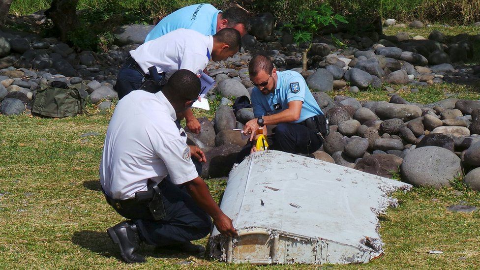 Police inspect a large piece of plane debris which was found on the beach in Saint-Andre, on the French Indian Ocean island of La Reunion. Photo: July 2015