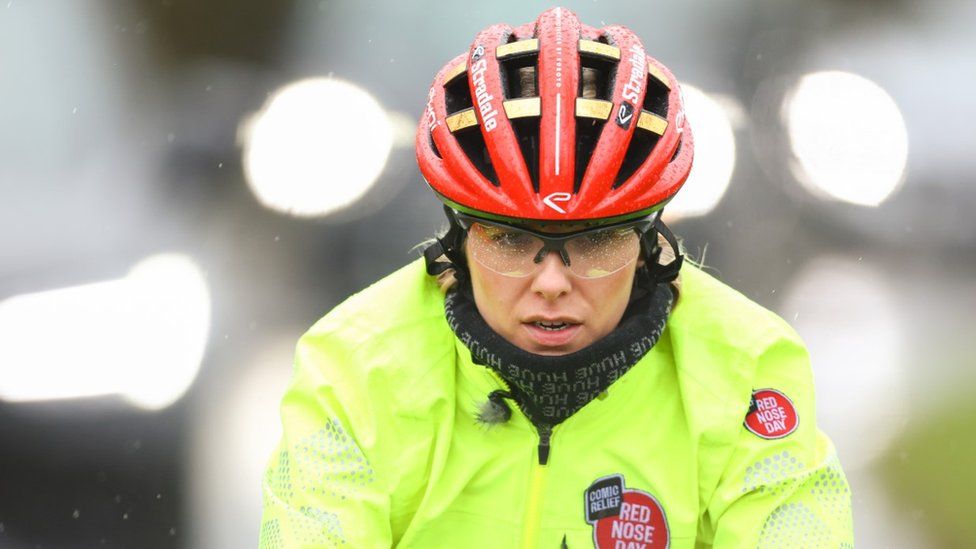 Mollie King cycling for Red Nose Day in wet conditions