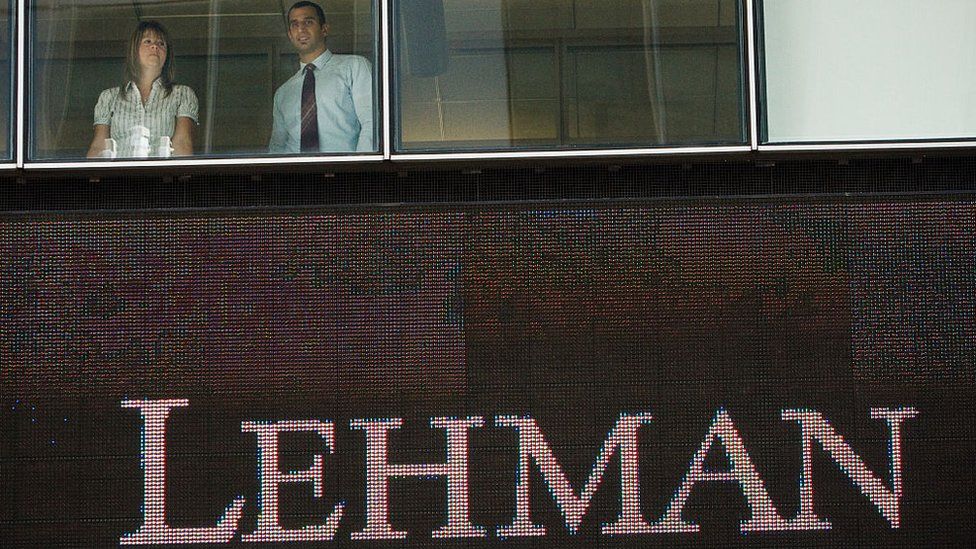 Employees look out of the now defunct Lehman Brothers headquarters in New York.
