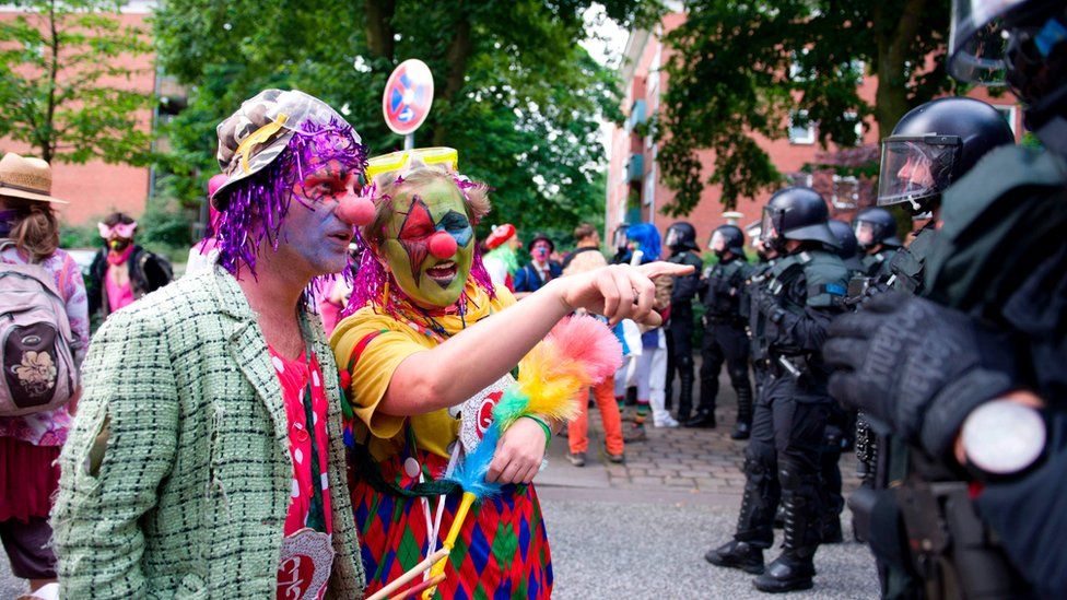Demonstrators dressed as clowns face policemen as they take part in a protest titled "#BlockG20 - Color the Red Zone" on July 7, 2017 in Hamburg, northern Germany,
