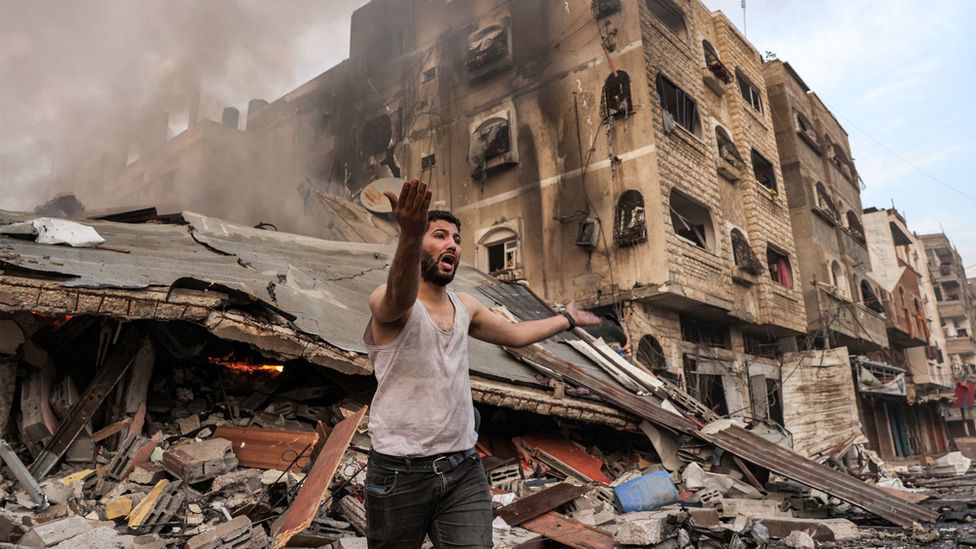 Gaza resident outside bombed buildings in Gaza