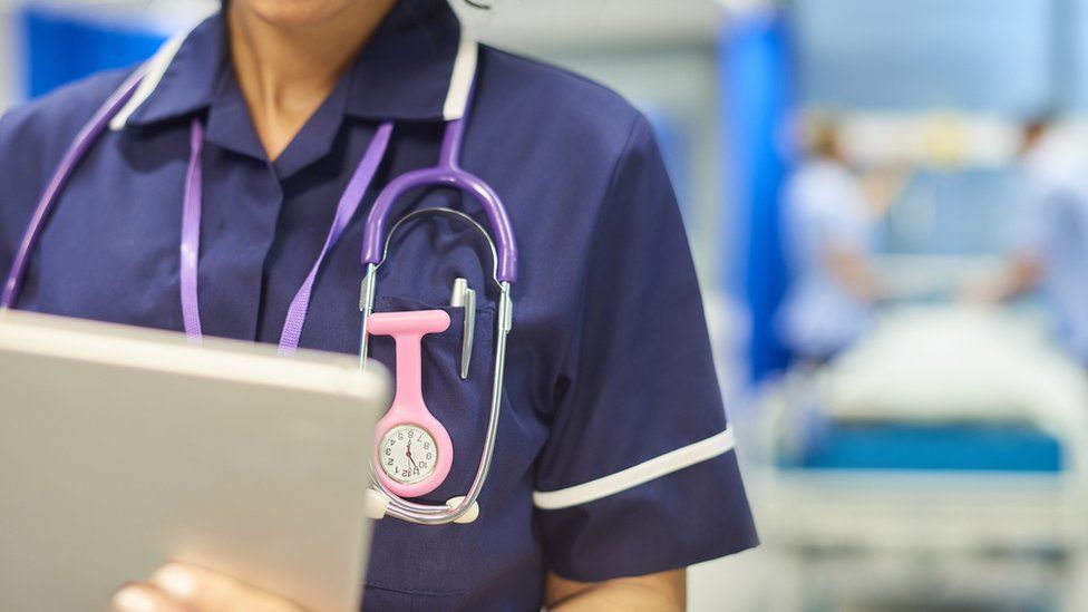 A nurse works on a hospital ward - stock image