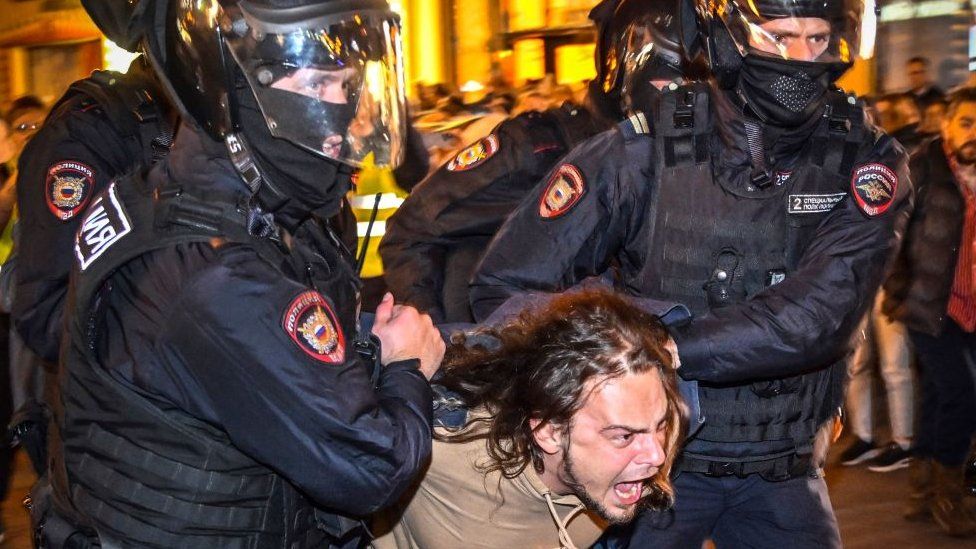 Полицейские задерживают мужчину после призывов протестовать против частичной мобилизации, объявленной президентом России, в Москве, 21 сентября 2022 г.