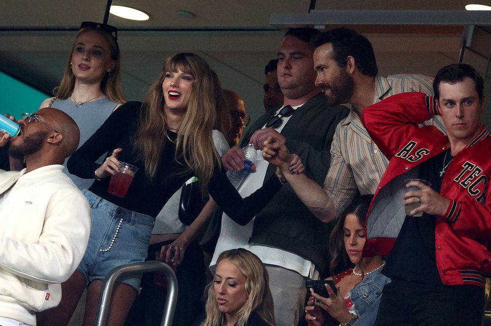 Певица Тейлор Свифт и актер Райан Рейнольдс беседуют перед игрой между «Канзас-Сити Чифс» и «Нью-Йорк Джетс» на стадионе «МетЛайф» 1 октября 2023 г.