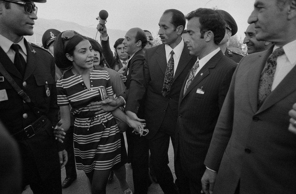 Bodyguards intervene when a young Iranian woman wants to talk to Shah Mohammad Reza Pahlavi who is visiting, with Queen Farah, the press centre of the Persepolis celebration in 1971