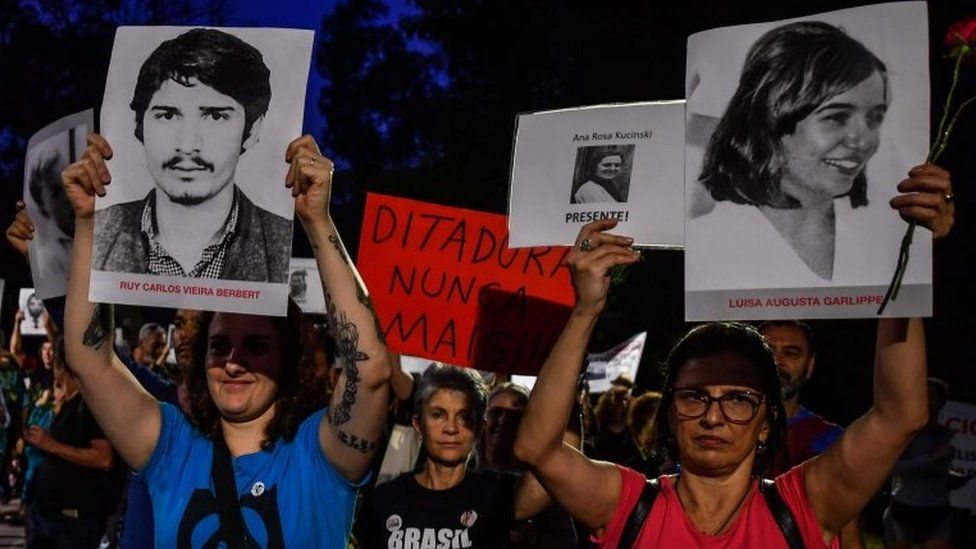 People holding pictures of people who were killed or went missing during the 1964-1985 dictatorship, demonstrate on the 55th anniversary of the military coup, at Ibirapuera Park, in Sao Paulo, Brazil, on March 31, 2019