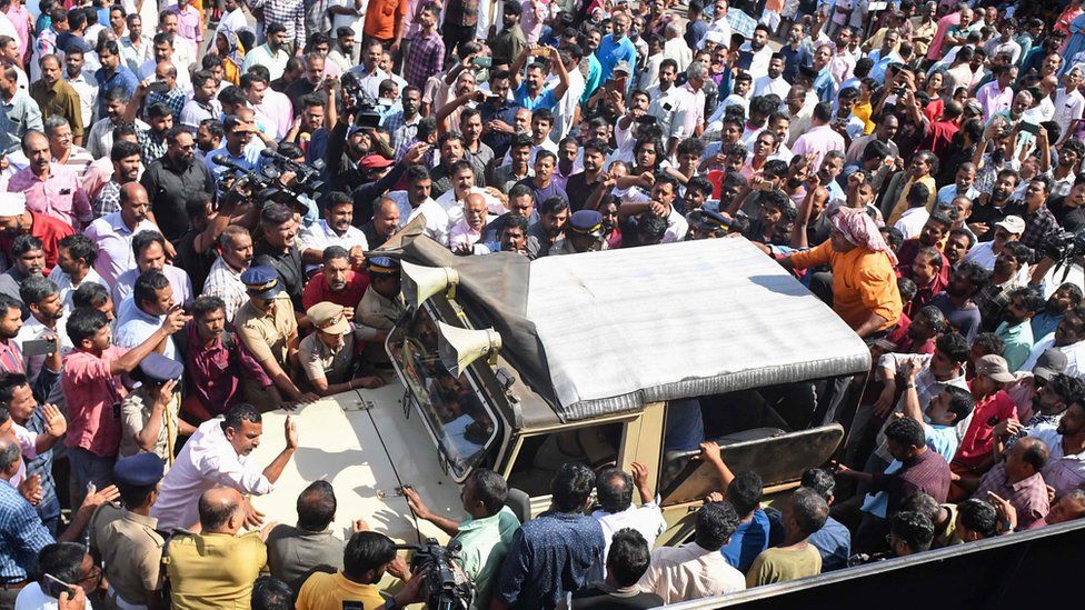 An angry mob blocks a forest department vehicle during a hartal by various political parties following the death of Paul in an elephant attack.