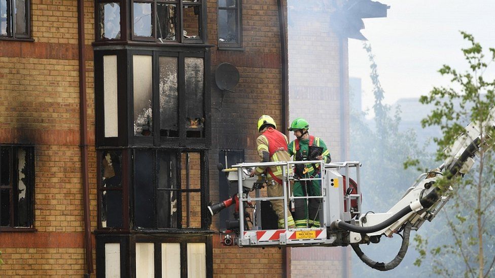 Fire crews continue spraying water into the block of flats