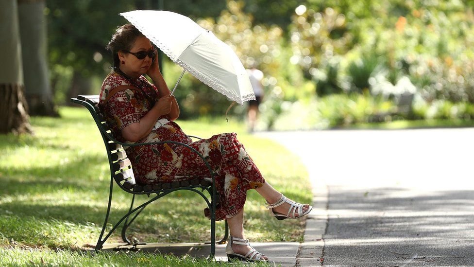 A woman takes shelter in the shade at Flagstaff Gardens on January 25, 2019 in Melbourne