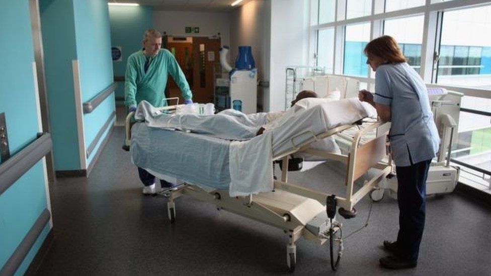 Nursing staff with patient on trolley