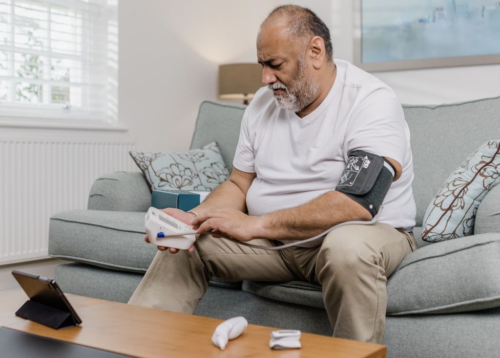 Man using a blood pressure monitor at home