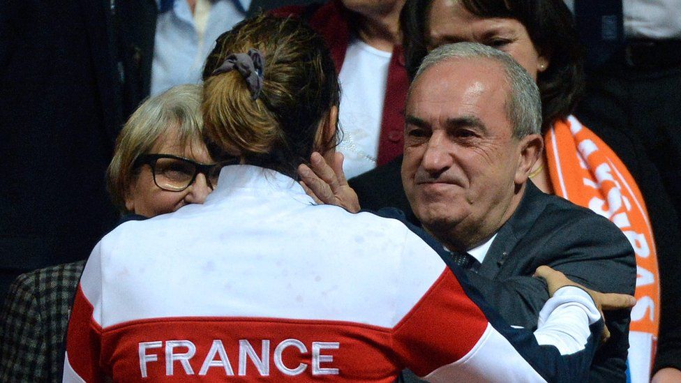 French Tennis Federation president Jean Gachassin (back) congratulates France"s Fed Cup captain Amelie Mauresmo after France won the Fed Cup semi-final against the Netherlands in Trelaze, northwestern France, on April 17, 2016.
