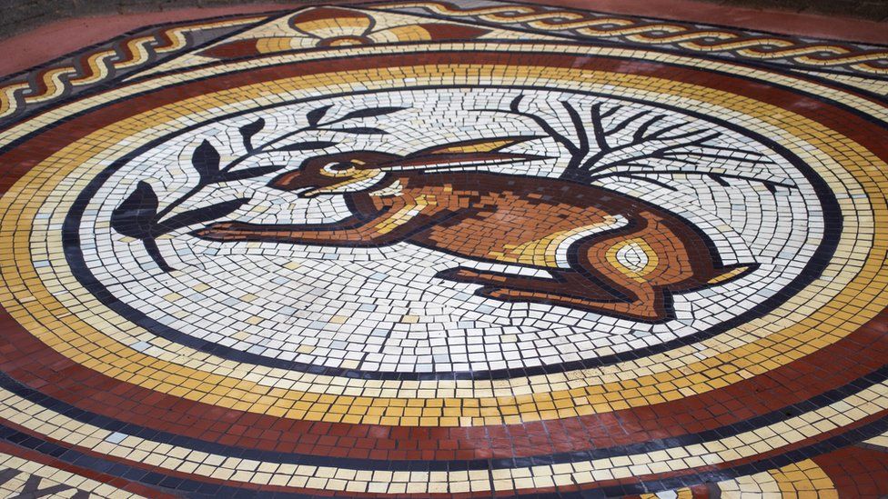 Image of the hare mosaic in Cirencester. It shows a hare in the centre, with yellow and red rings around it