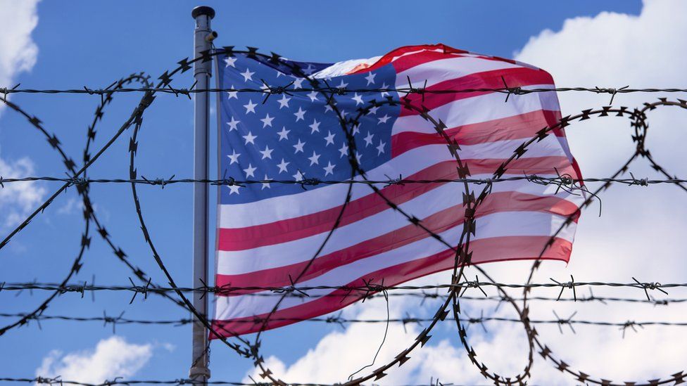 American flag behind barbed wires