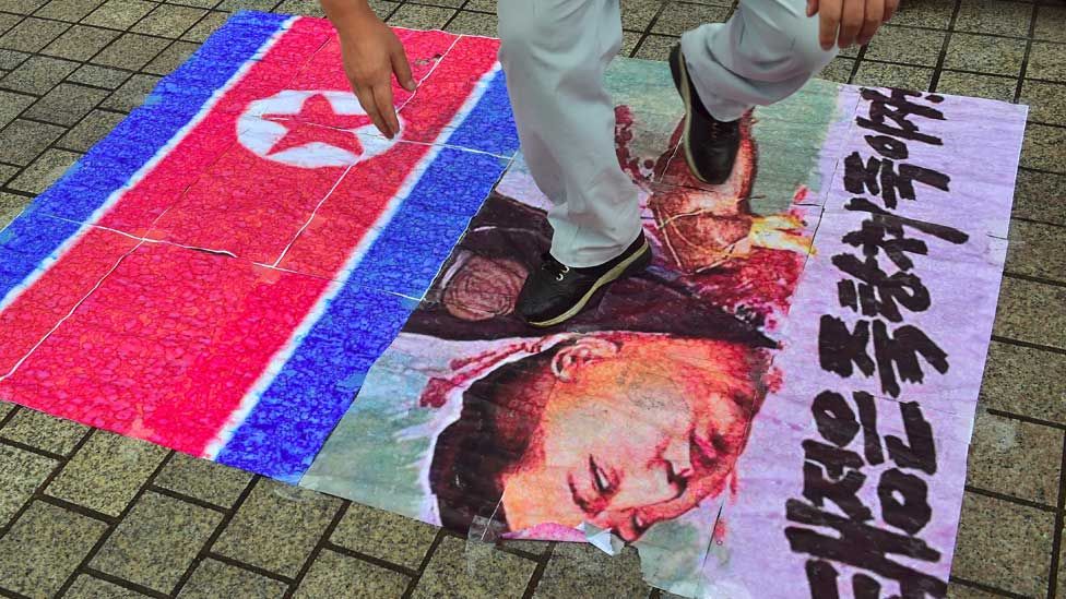 South Korean activist tramples on an caricature picture of North Korean leader Kim Jong-Un during a protest in Seoul