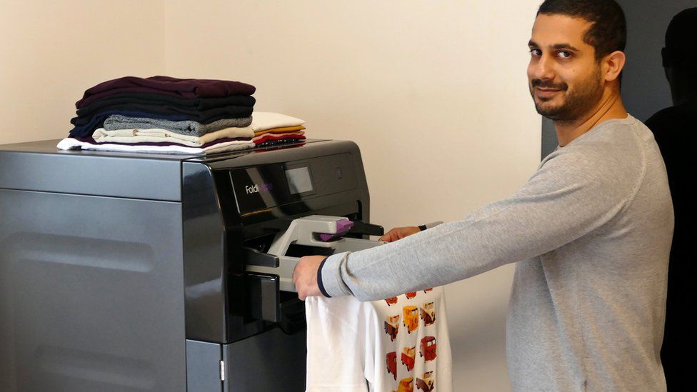 A man uses Foldimate to automatically fold clothes