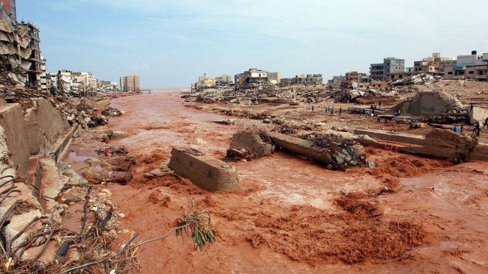 People look at the damage caused by freak floods in Derna, eastern Libya, 11 September 2023