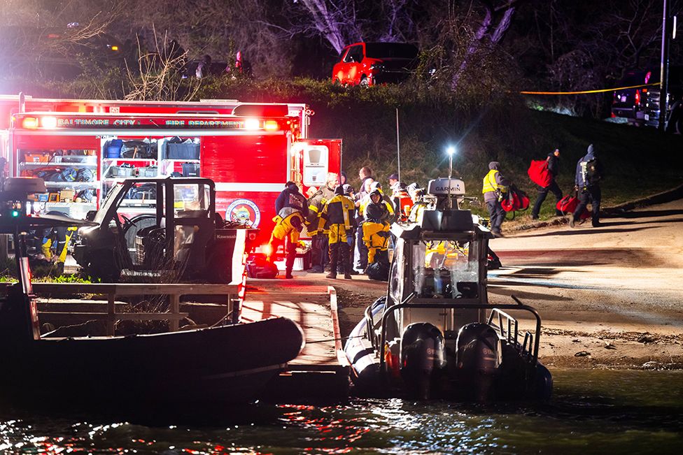 Rescue personnel gather on the shore of the Patapsco River after a cargo ship ran into the Francis Scott Key Bridge causing its collapse, in Baltimore, Maryland, USA, on 26 March 2024