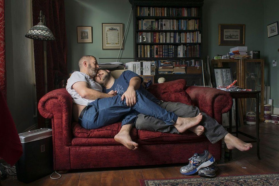 Portrait of a male couple on a sofa cuddling