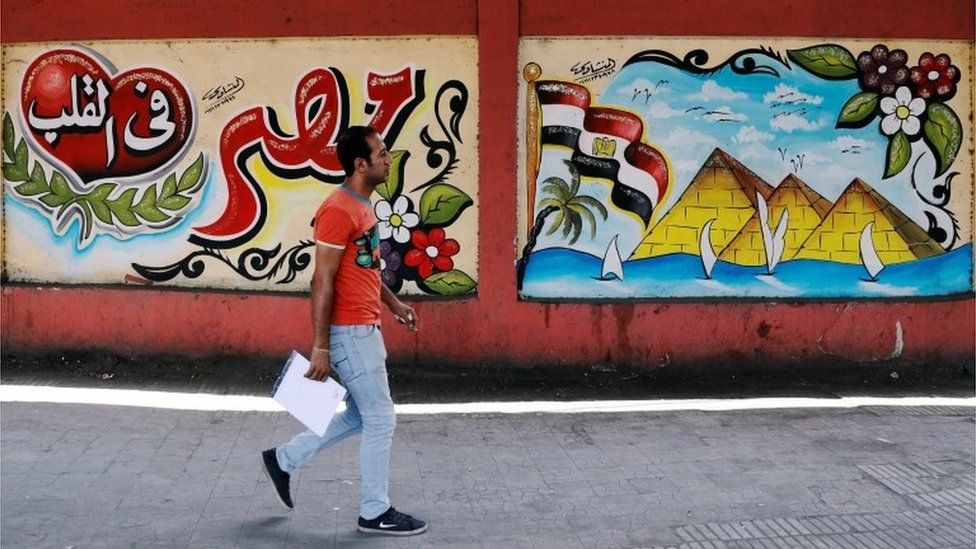 A man walks in front of graffiti in Cairo, Egypt - Monday 6 August 2018