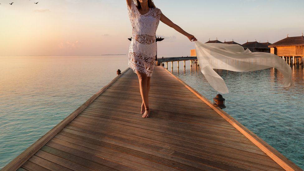 Stock image of a woman on a jetty in exotic sea resort