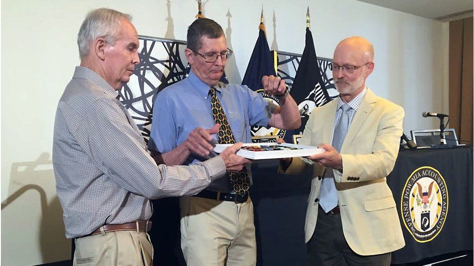 Elderly sons of Korean war veteran hold father's dog tags