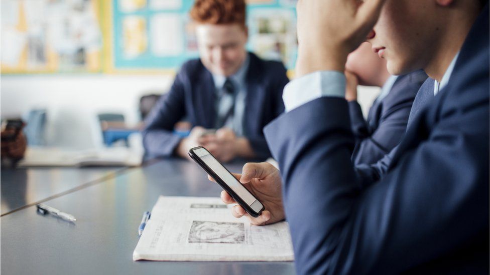 A pupil looking at his phone