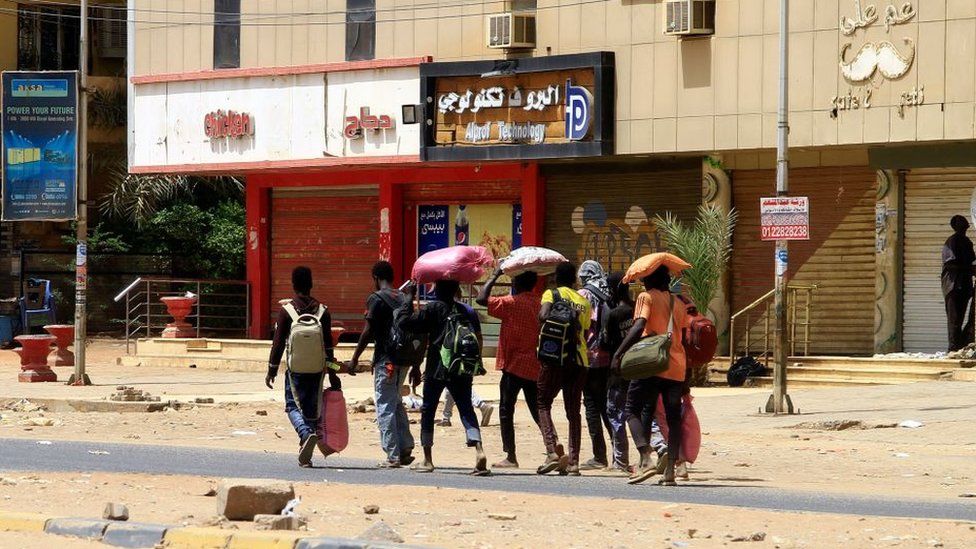 people carry belongings, khartoum 16 april