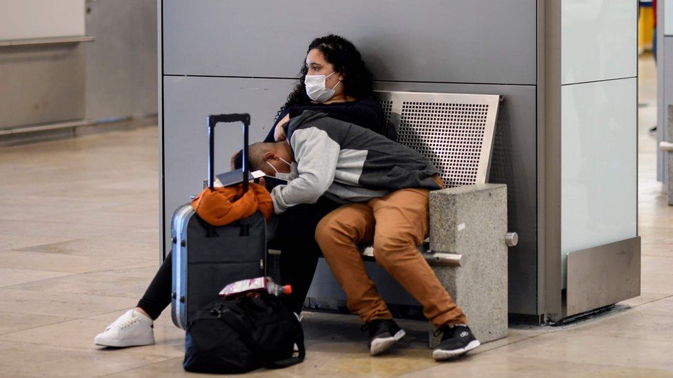 Woman and child in airport wearing masks.