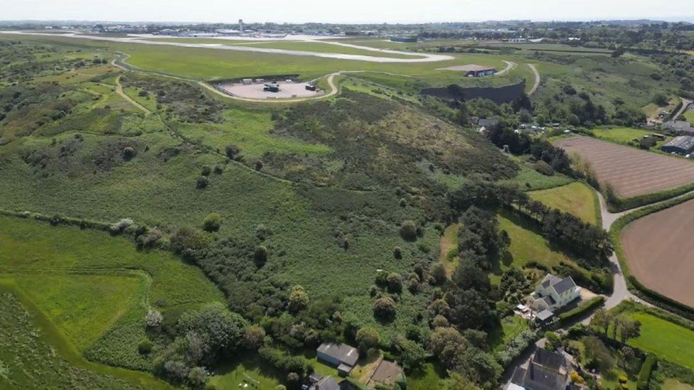 Aerial view of houses and farms and Jersey Airport including the fire training ground