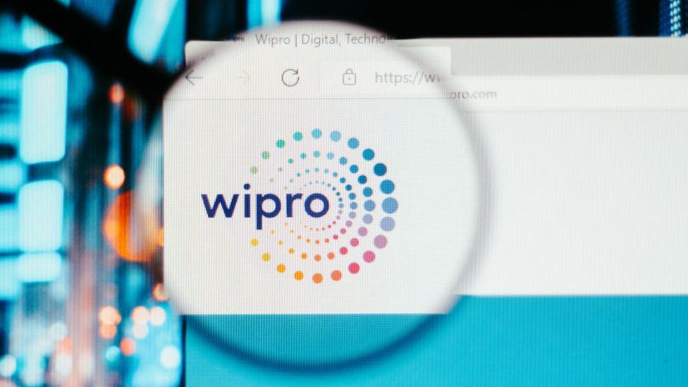 эта фотоиллюстрация, домашняя страница веб-сайта Wipro Technologies, видимая на экране компьютера через увеличительное стекло.