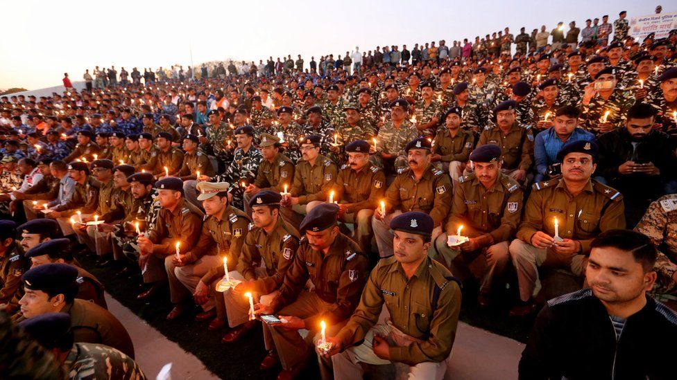 Central Reserve Police Force and Rapid Action Force soldiers and their family members hold candles as they pay tribute to personnel during a candlelight vigil in Bhopal