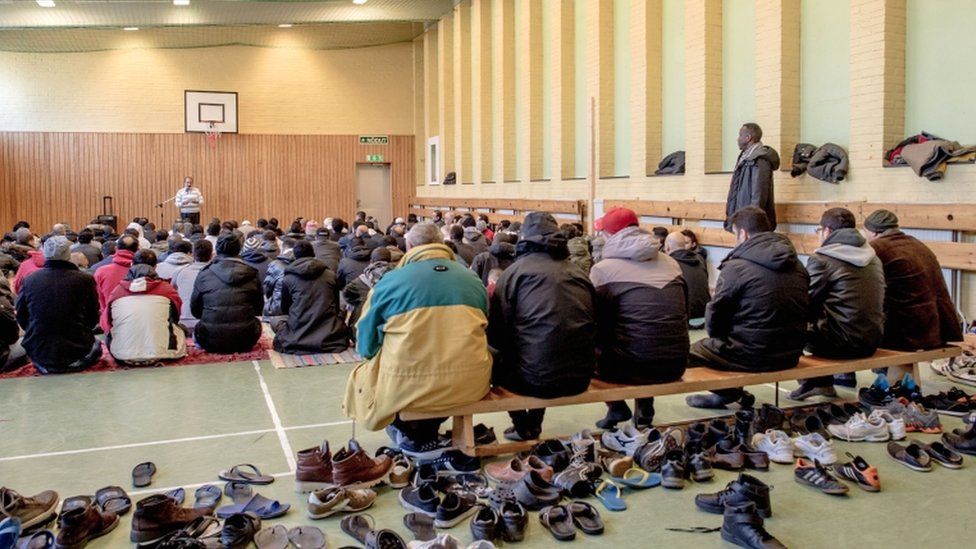 Refugees pray in the gym of the Sweden's largest temporary camp for refugees at the former psychiatric hospital Restad Gard in February 2016 in Vanersborg, Sweden