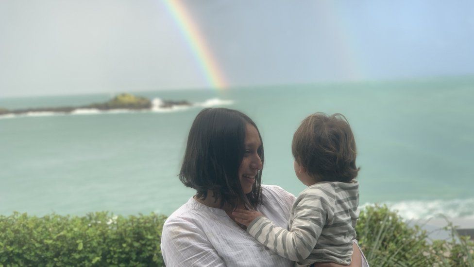 Tulip and her son looking out towards a rainbow.