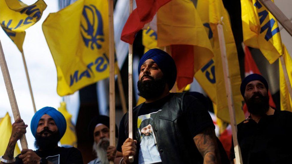People hold flags during a Sikh rally outside the Indian consulate in Toronto to raise awareness for the Indian government's alleged involvement in the killing of Sikh separatist Hardeep Singh Nijjar in British Columbia on September 25, 2023