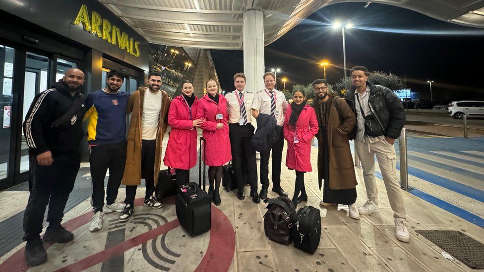 Hassan Khan and his friends pose with members of cabin crew, the pilot and co-pilot outside Brindisi Airport