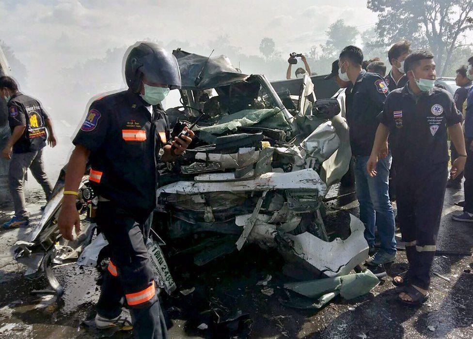 Thai rescue workers inspect a wreckage pickup truck after collided with a passenger van vehicles and both were burned in the accident at a highway in Chonburi province, Thailand, 2 January 2017